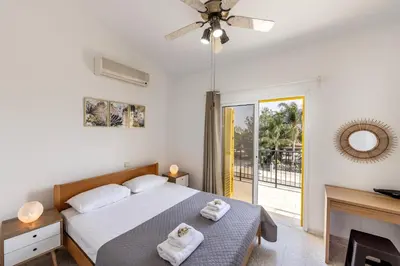 a bedroom with a bed and a fireplace and a tv at Ayia Thekla Sea Breeze Villa in Ayia Napa