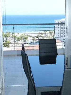 a balcony with a table and chairs and the ocean at Aphrodite Heights in Larnaka