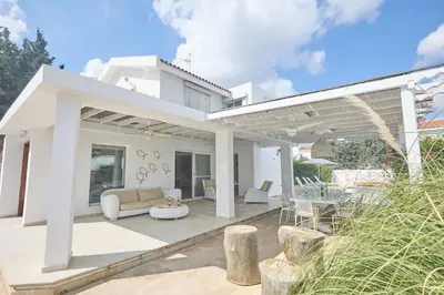 a white house with a patio with a couch and chairs at Protaras Serifos Villa Sv07 in Paralimni