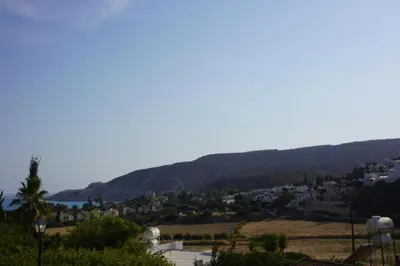 a view of a town with mountains in the background at Skeleas Apartments in Pissouri