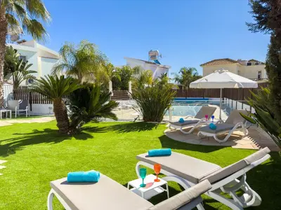 a backyard with a swimming pool and lawnitures at Ayia Napa Holiday Villa 040 in Ayia Napa
