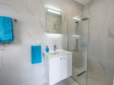 a white bathroom with a sink and a shower at Ayia Napa Holiday Villa 040 in Ayia Napa