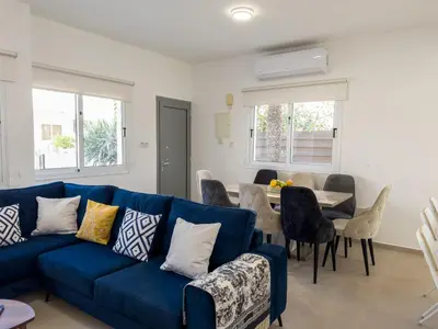 a living room with a blue couch and a table at Ayia Napa Holiday Villa 040 in Ayia Napa