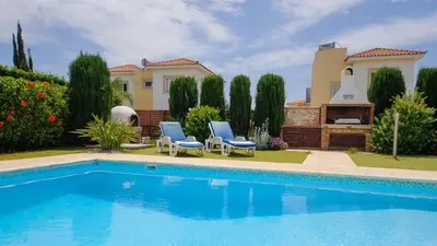 a villa with a swimming pool in front of a house at Ayia Napa Holiday Villa 036 in Ayia Napa