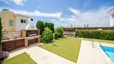 a garden with a swimming pool and a house at Ayia Napa Holiday Villa 036 in Ayia Napa