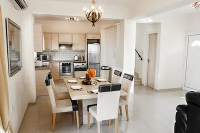 a kitchen and dining room with a table and chairs at Protaras Holiday Villa 035 in Protaras