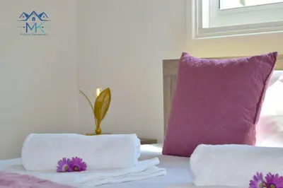 a bed with two pillows and a purple pillow at SeaWitch Apartment in Larnaka