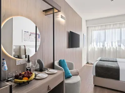 a hotel room with a bed and a table with fruit on it at Mercure Larnaca Finikoudes Beach in Larnaka