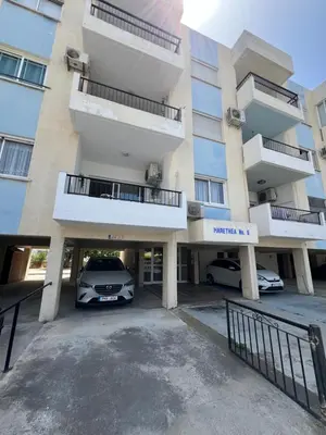 a car parked in a parking lot in front of a building at Marethea rooms in Larnaka