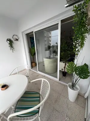 a white table and chairs in a room with plants at Marethea rooms in Larnaka