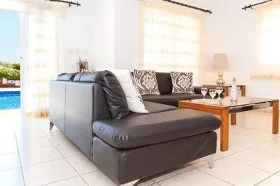 a living room with a couch and a table at Villa Cypriana in Protaras