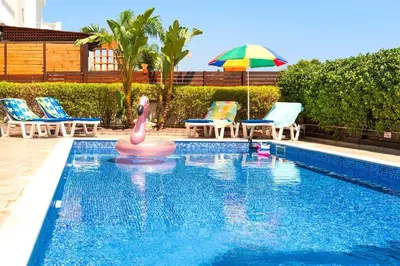 a swimming pool with a pink flamingo in the water at Villa Cypriana in Protaras