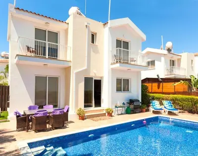 a villa with a swimming pool in front of a house at Villa Cypriana in Protaras