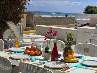 a table with fruit and wine glasses on a patio at Sandy Coast Beach Villa in Larnaka