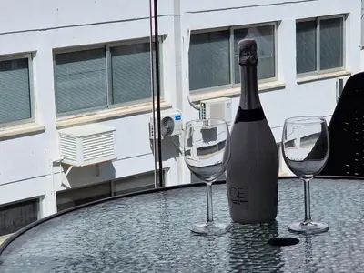 a bottle of wine sitting on a table with two wine glasses at Tropical Paradise 200m from Finikoudes beach in Larnaka