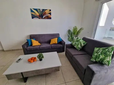 a living room with two couches and a coffee table at Tropical Paradise 200m from Finikoudes beach in Larnaka