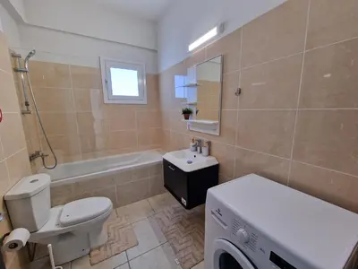 a bathroom with a toilet and a sink and a tub at Tropical Paradise 200m from Finikoudes beach in Larnaka