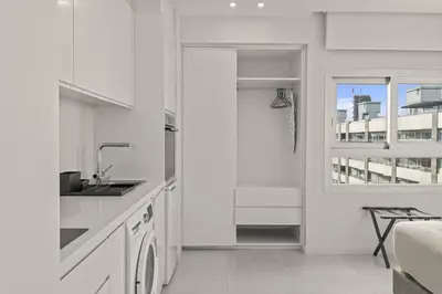 a white kitchen with a sink and a window at Phaedrus Living: Limassol Seaside Residences 05 in Limassol