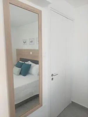 a mirror reflection of a bed in a bedroom at Green Bay Suites in Protaras