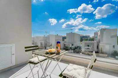 a table and chairs on a balcony with a view of a city at NEW 2BR Townhouse in Luxury Resort Pool & Beach in Protaras
