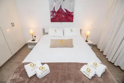 a bedroom with a large white bed with three pillows at Quattro City Center Apartments in Larnaka
