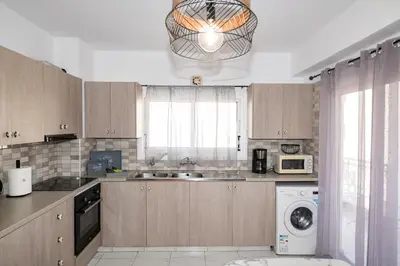 a kitchen with a washer and a sink and a dishwasher at Quattro City Center Apartments in Larnaka