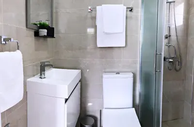 a bathroom with a toilet and a sink and a shower at Luxury Stay at Mackenzie Beach with Private Parking and Balcony in Larnaka