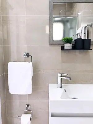a bathroom with a white sink and a mirror at Luxury Stay at Mackenzie Beach with Private Parking and Balcony in Larnaka