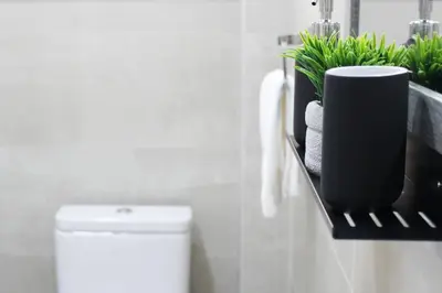 a bathroom with a toilet and a shelf with towels at Luxury Stay at Mackenzie Beach with Private Parking and Balcony in Larnaka