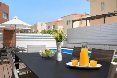 a black table with drinks and a vase of flowers at Villa Sunrise Glory - 150m from Trinity Beach in Protaras