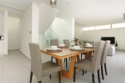 a dining room with a wooden table and chairs at Villa Sunrise Glory - 150m from Trinity Beach in Protaras
