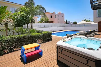 a hot tub on a deck next to a pool at Villa Sunrise Memory - 150m from Trinity Beach in Protaras