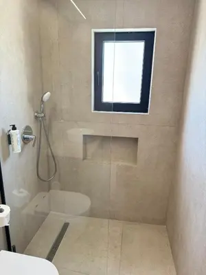 a bathroom with a shower and a window at Home of the Muses in Ayia Napa