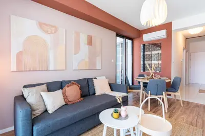 a living room with a blue couch and a table at Arion 1-Bedroom Apartment in Larnaca in Larnaka