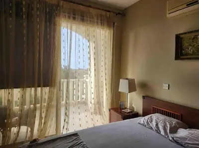 a bedroom with a bed and a large window at Budget Escape to the seaside in Larnaka