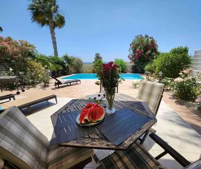 a wooden table with a plate of watermelon on it at Budget Escape to the seaside in Larnaka