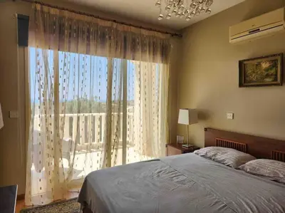 a bedroom with a bed and a large window at Budget Escape to the seaside in Larnaka