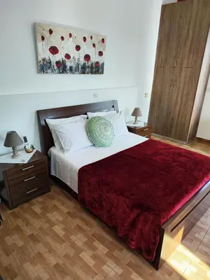a bedroom with a large bed with a red blanket at Mariam Apartment in Larnaka