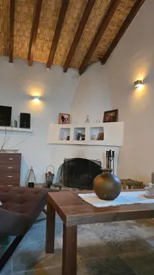 a living room with a table and a fireplace at GPPh in Pelendri