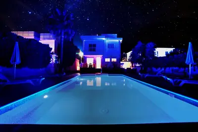 a swimming pool in front of a house at night at Villa Chloe in Ayia Napa