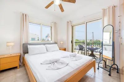 a bedroom with a large bed and a balcony at Pernera Blue Villa in Protaras