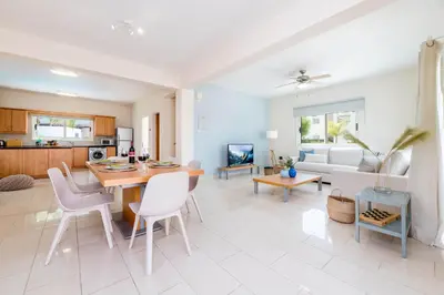 a kitchen and living room with a table and chairs at Pernera Blue Villa in Protaras