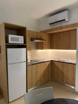 a kitchen with a white refrigerator and a microwave at Kritamo Beach Hotel Apartments in Ayia Napa