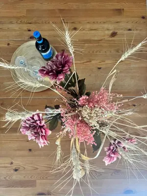 a bouquet of flowers on a table with a bottle at Villa Calm 100m from the beach in Ayia Napa
