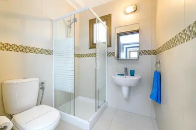 a bathroom with a shower and a toilet and a sink at Kymma Bungalow #2 in Ayia Napa