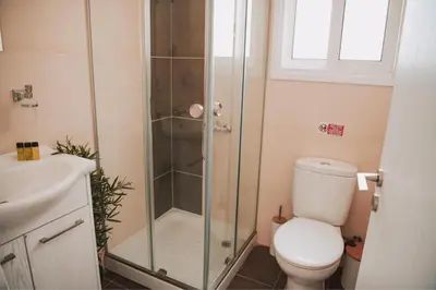 a bathroom with a shower with a toilet and a sink at Mercury Apartment in Livadhia