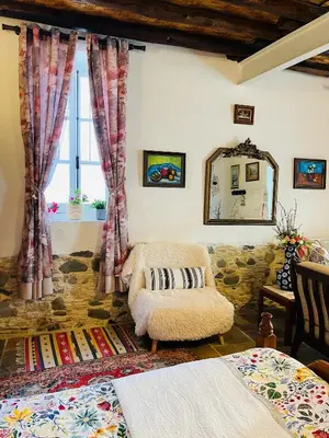 a living room with a chair and a window at Traditional House in Pera in Pera