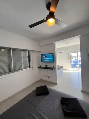 a living room with a ceiling fan and a television at Top floor Flat in Nicosia 2 in Nicosia