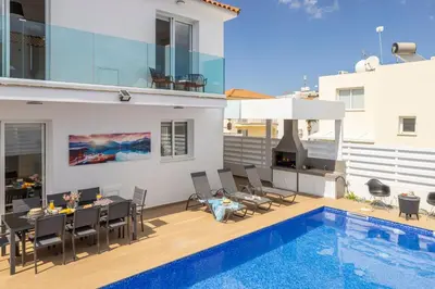 a patio with a dining table and a swimming pool at The Second Diamond Protara - 2' Walk to Beach in Protaras