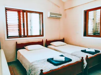 two beds in a room with two windows at Villa Elena Gardens in Ayia Napa
